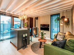 A modern living room with a sofa, a coffee table, and a fireplace. - Bon Zoutelande by Interhome (Zoutelande)
