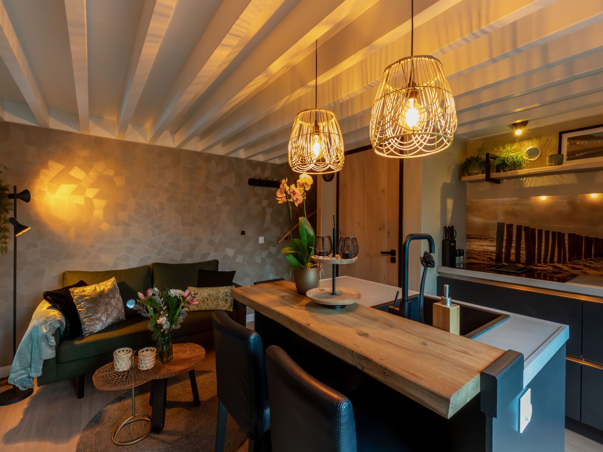 Une cuisine moderne dotée d’un îlot central en bois, de luminaires suspendus et d’une cuisinière intégrée.