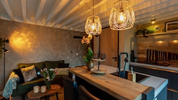 Une cuisine moderne dotée d’un îlot central en bois, de luminaires suspendus et d’une cuisinière intégrée.