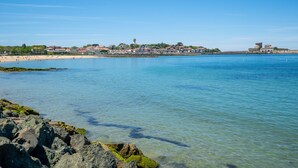 Eine Küstenstadt mit klarem, blauem Wasser, felsigem Ufer und Gebäuden direkt am Strand.