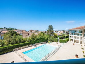 A swimming pool with a view of a residential area and a building with balconies. - Golf de la Nivelle by Interhome (Saint-Jean-de-Luz)
