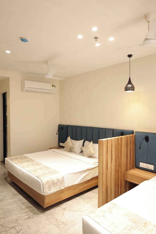 A modern bedroom with a wooden headboard, a large bed, an air conditioning unit, and a pendant light.