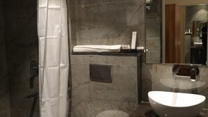 Et moderne badeværelse med brusebad, toilet og håndvask.