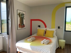 A bedroom with a bed, a window, a wall-mounted artwork, and a bedside table. - In the heart of the countryside, close to the most beautiful sites in Périgord Noir. (Cénac-et-Saint-Julien)