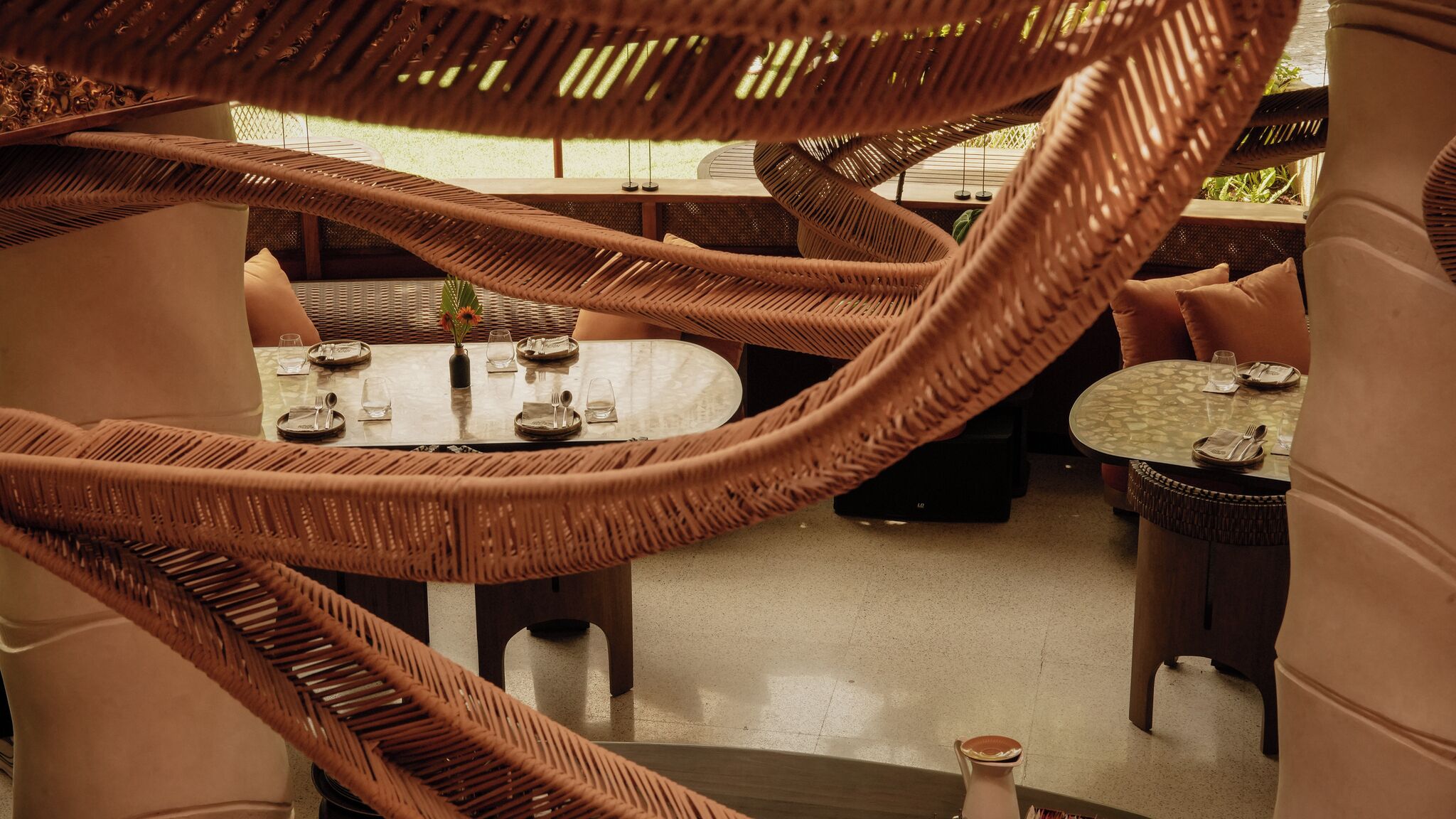 A restaurant with wicker furniture and a central dining table.