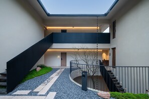 Ein modernes Gebäude mit Innenhof, Treppe und Dachfenster.