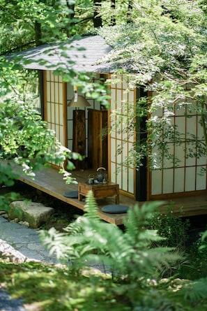 Una tradizionale casa giapponese in legno, con pavimenti in tatami, un piccolo portico e un set da tè.