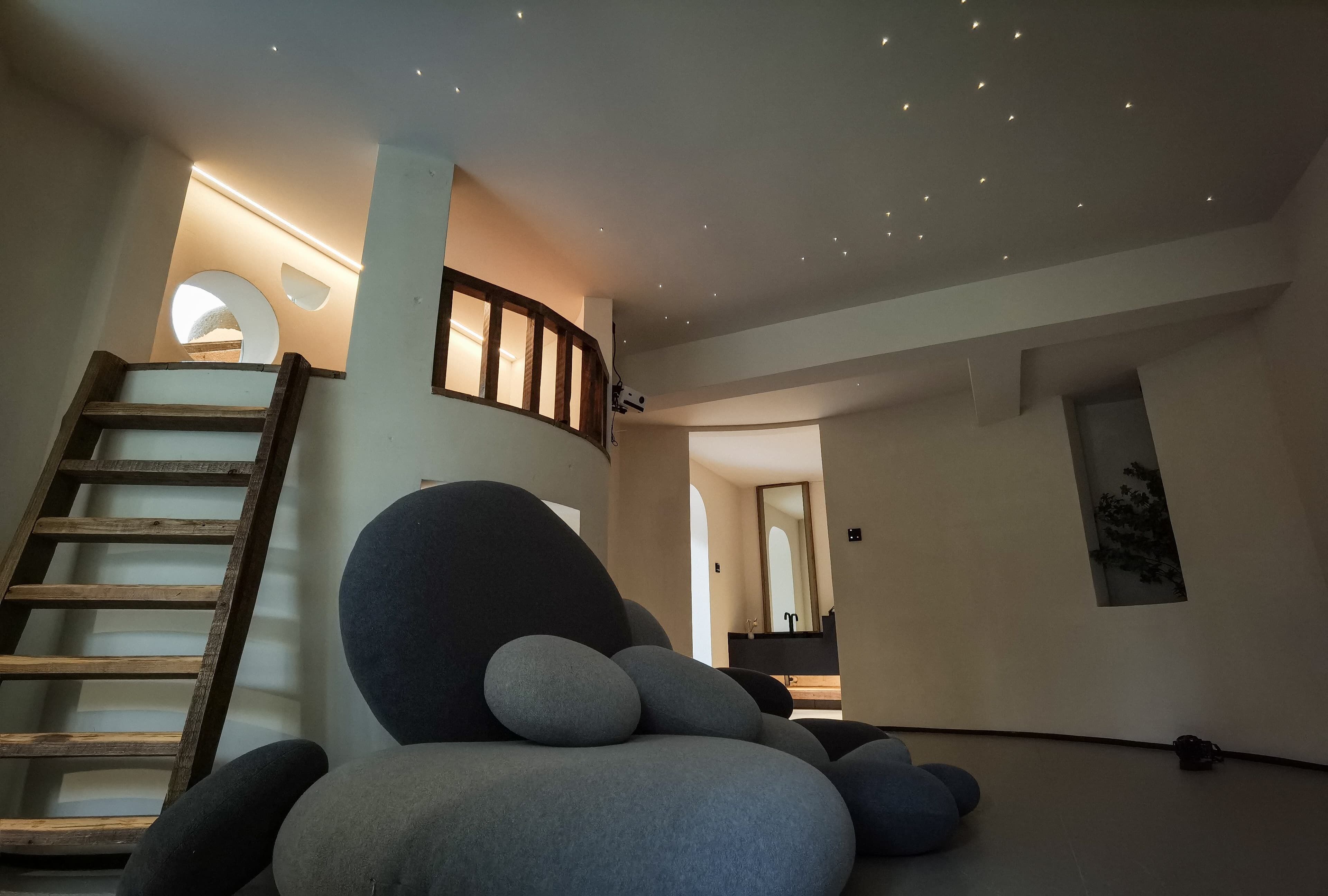 Un interior moderno con una escalera, un amplio espacio de asientos y vistas de la habitación contigua.