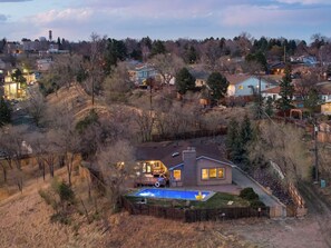 A residential area with houses, a swimming pool, and a hilly landscape. - 6k sq/ft Mansion! Heated Pool, Hot Tub, Game Room, Theatre, Unforgettable Views! (Colorado Springs)