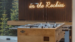 Ett fotbollsspel i trä med en neonreklamskylt ovanför som visar texten ”Wild in the Rockies”.