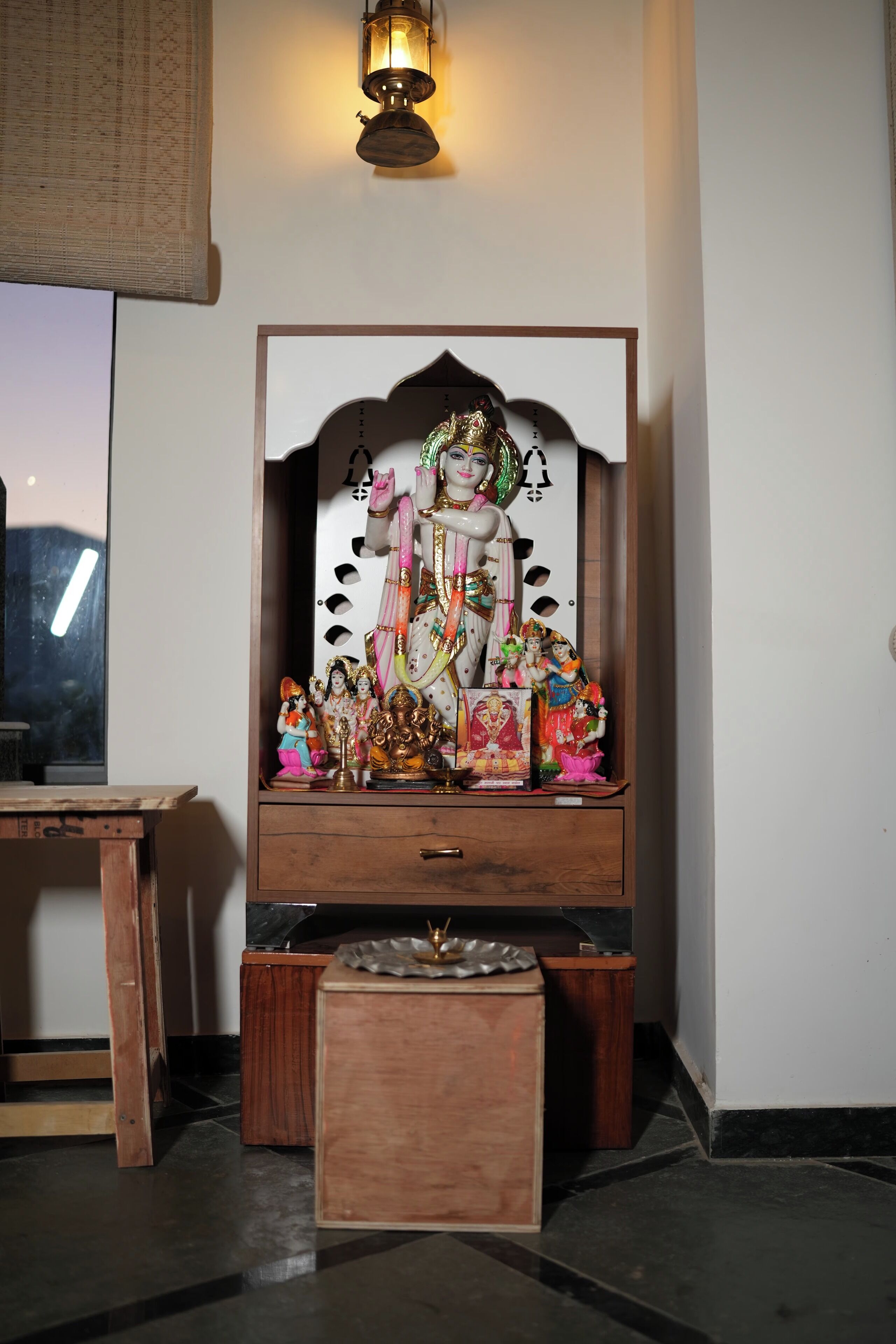 A shrine with a deity figure, small figurines, and a mirror.