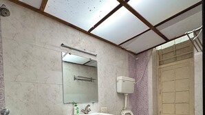 Een badkamer met een wastafel, toilet en spiegel.