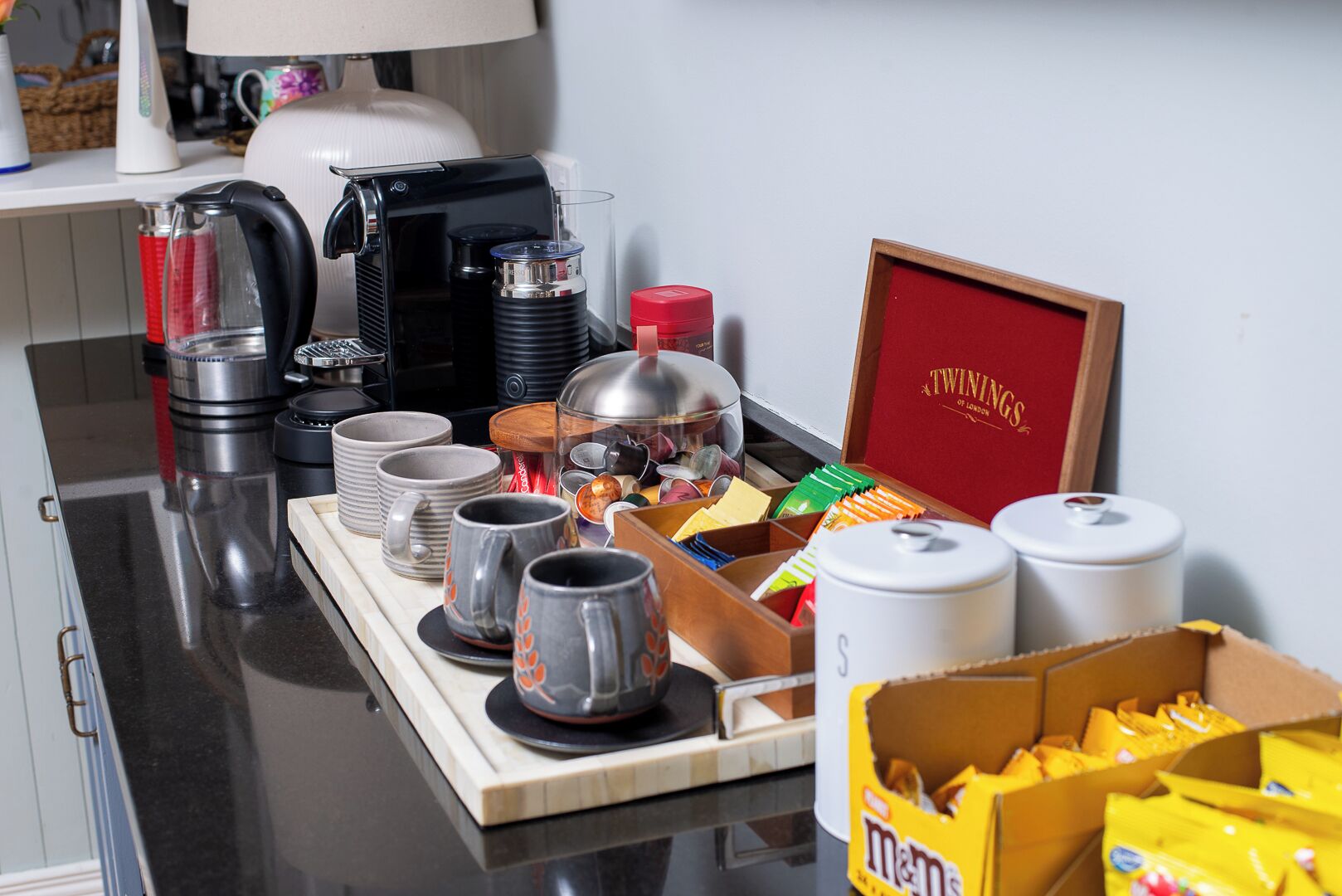A breakfast buffet setup with various food items, coffee machines, and a framed certificate on the counter.