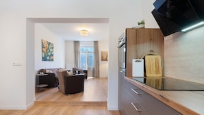 A modern kitchen with a built-in oven, a wooden countertop, and a small potted plant on the counter. - Apartment '2' with Private Terrace, Shared Garden and Wi-Fi (Rathmannsdorf)