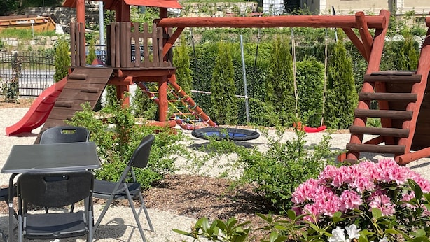 A playground with a slide, swings, and a climbing structure. - Apartment '2' with Private Terrace, Shared Garden and Wi-Fi (Rathmannsdorf)