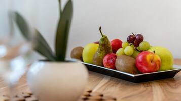 A fruit platter on a tray with a potted plant nearby.