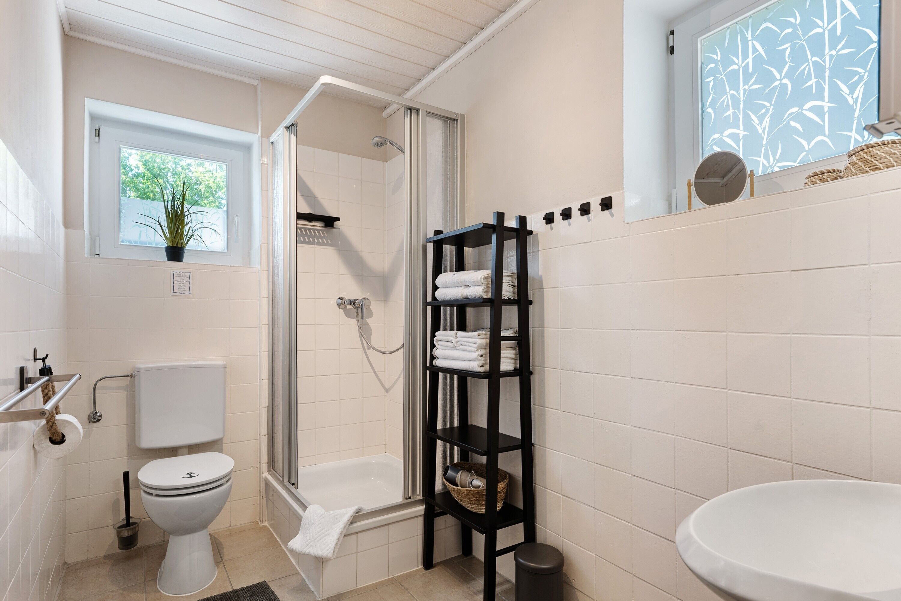 Et badeværelse med toilet, bruser og håndvask.