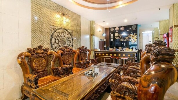Uma mesa de jantar de madeira tradicional com detalhes entalhados, rodeada por cadeiras ricamente decoradas.