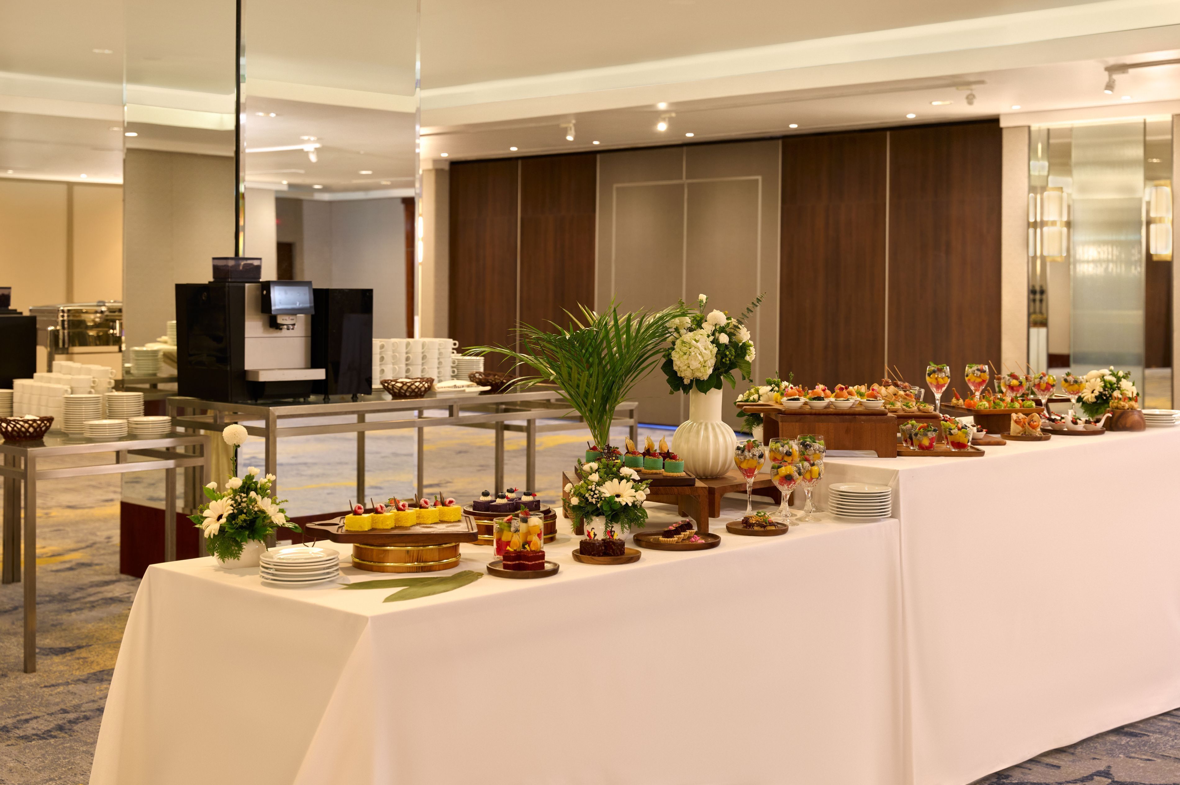A buffet setup with various food items and a coffee station in a hotel setting.
