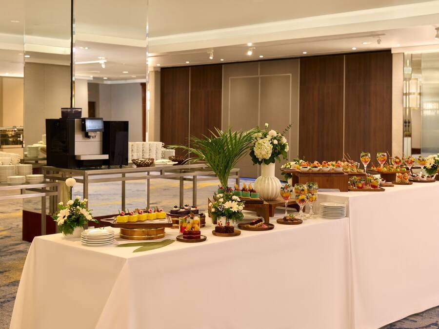 A buffet setup with various food items and a coffee station in a hotel setting.