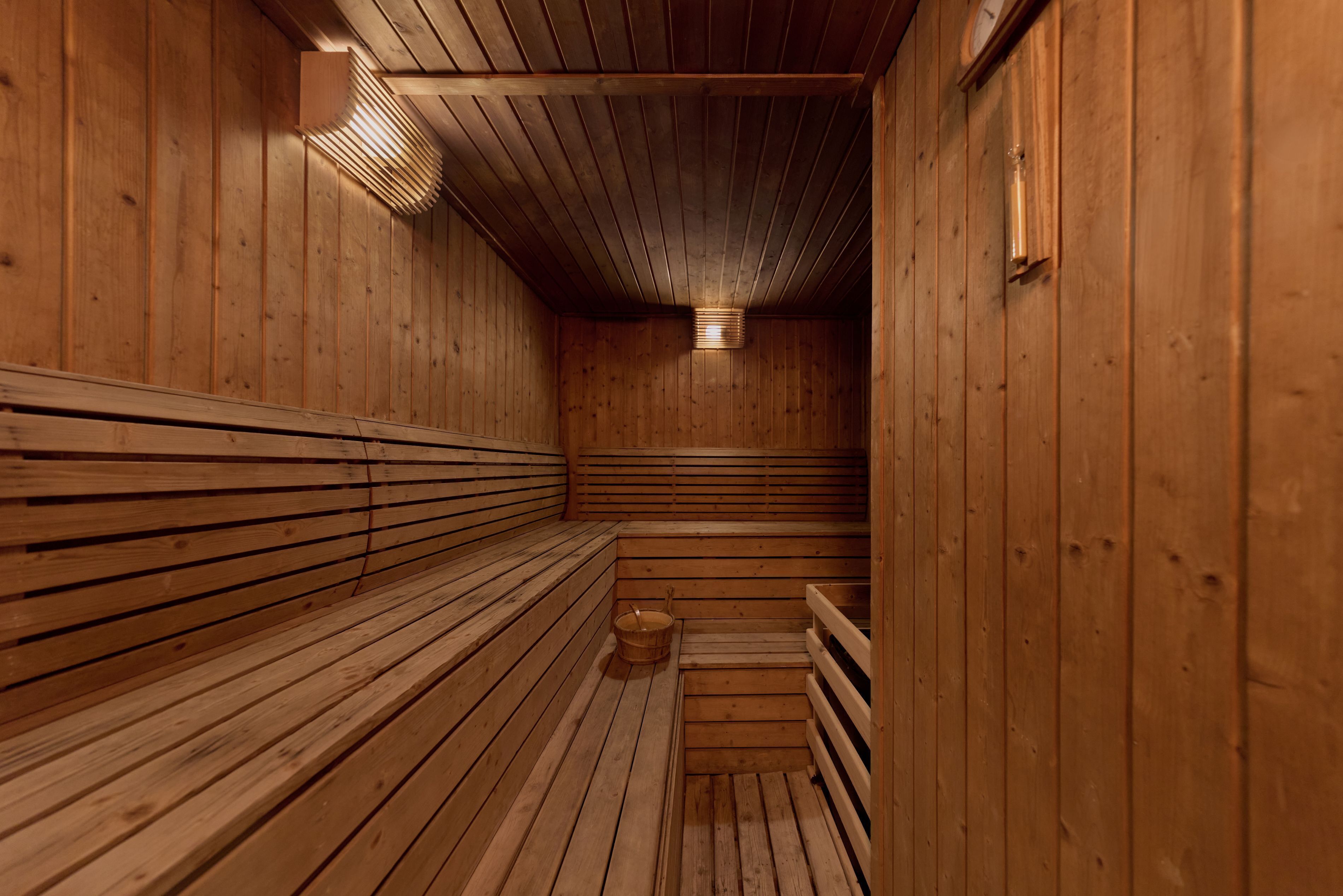 A sauna with wooden benches and a sloped ceiling.