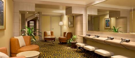 Un hall d’hôtel avec des sièges, un comptoir d’accueil et un grand miroir.