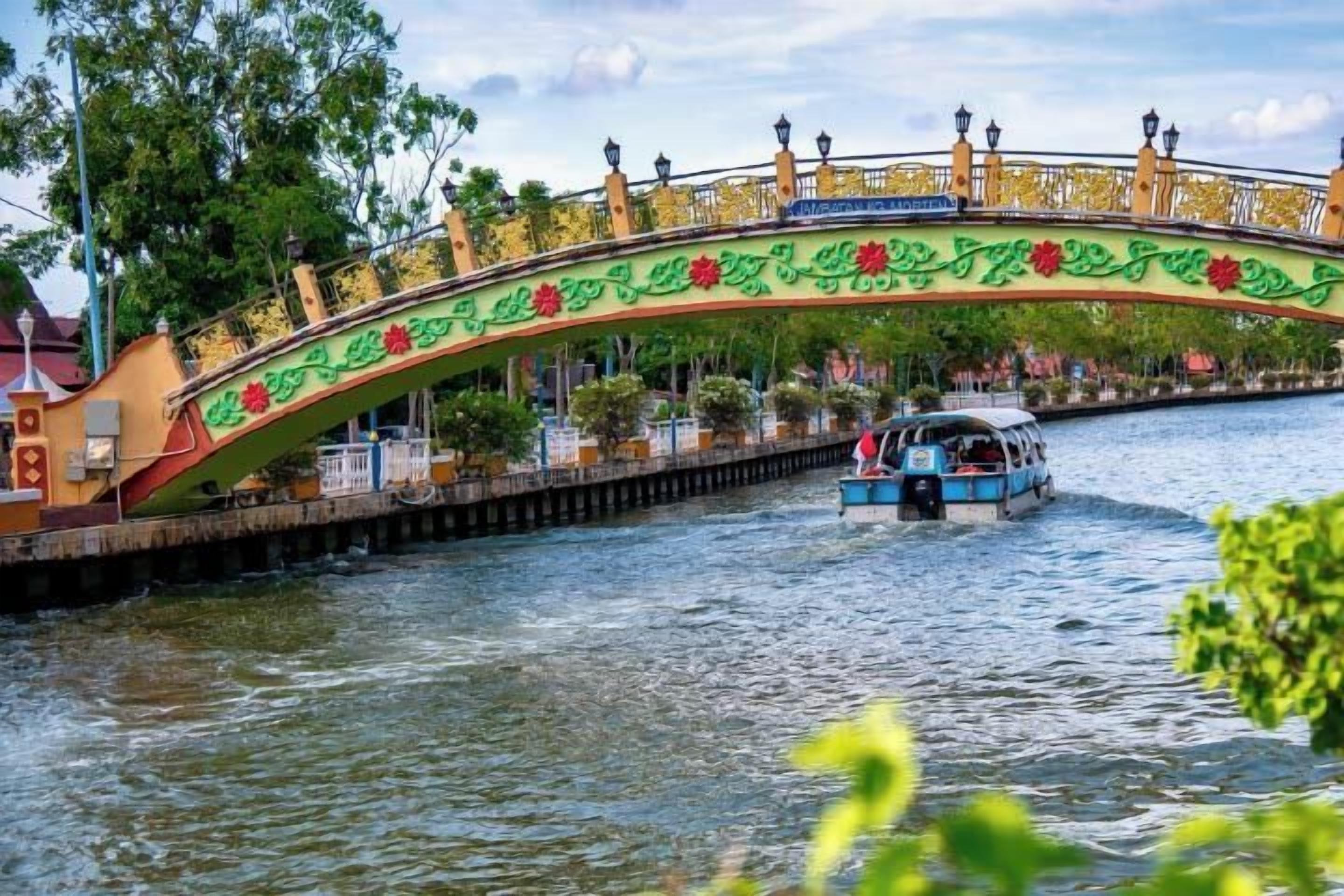Eine Brücke mit schmiedeeisernen Geländern und einem Boot auf einem Fluss.