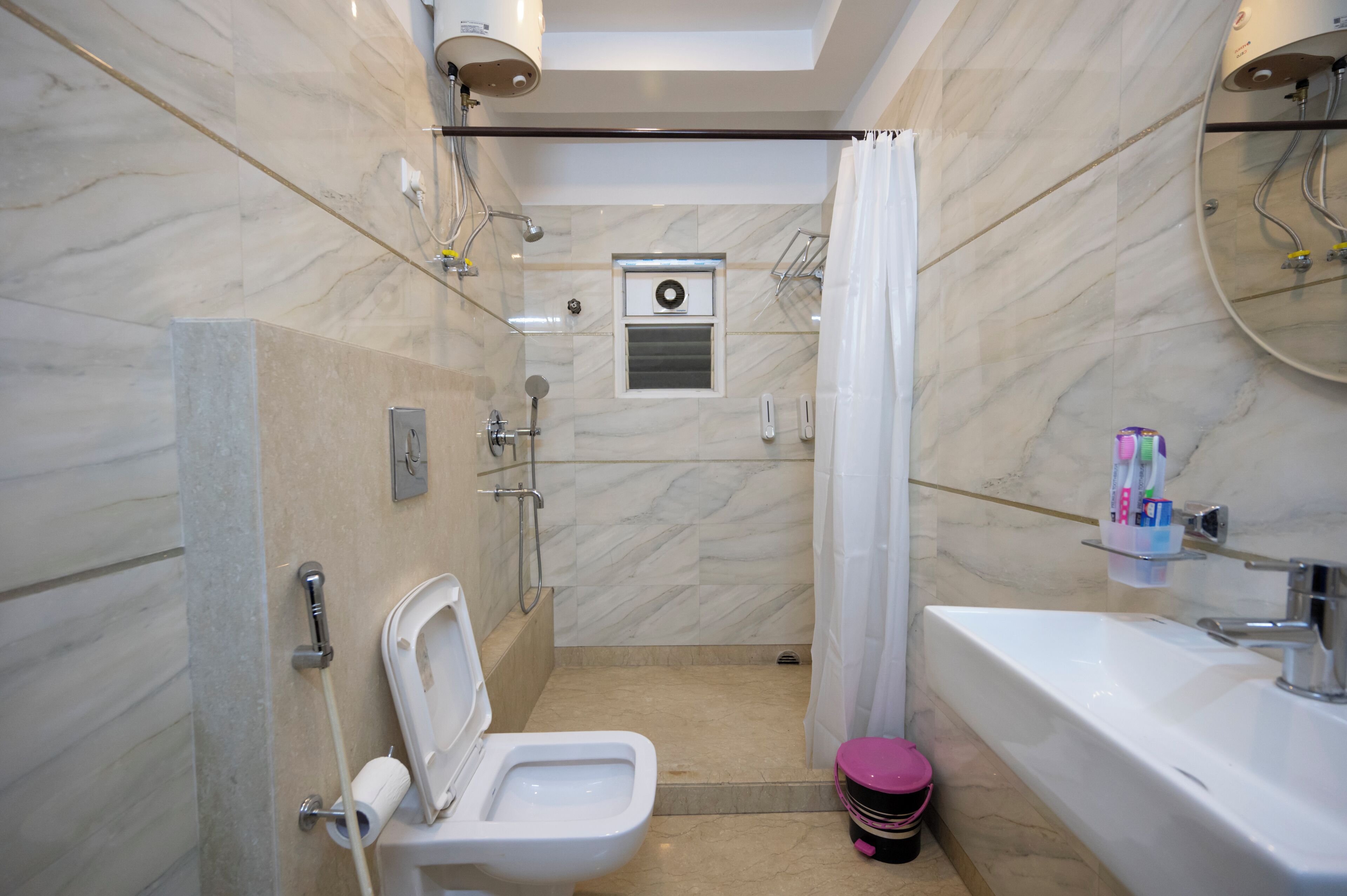 A modern bathroom with a shower, toilet, and sink.