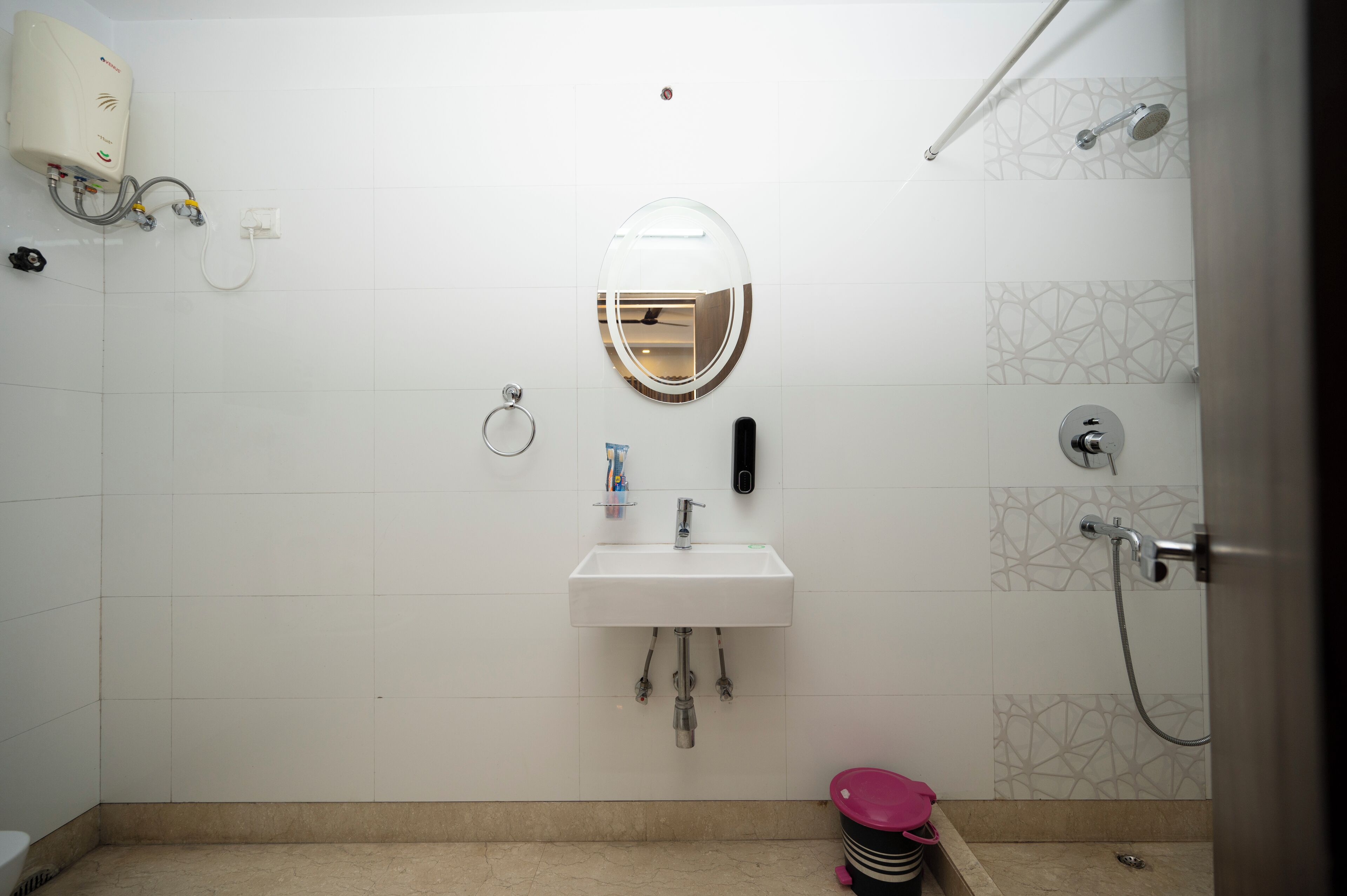 A bathroom with a white sink, a mirror, a toilet, and a shower.