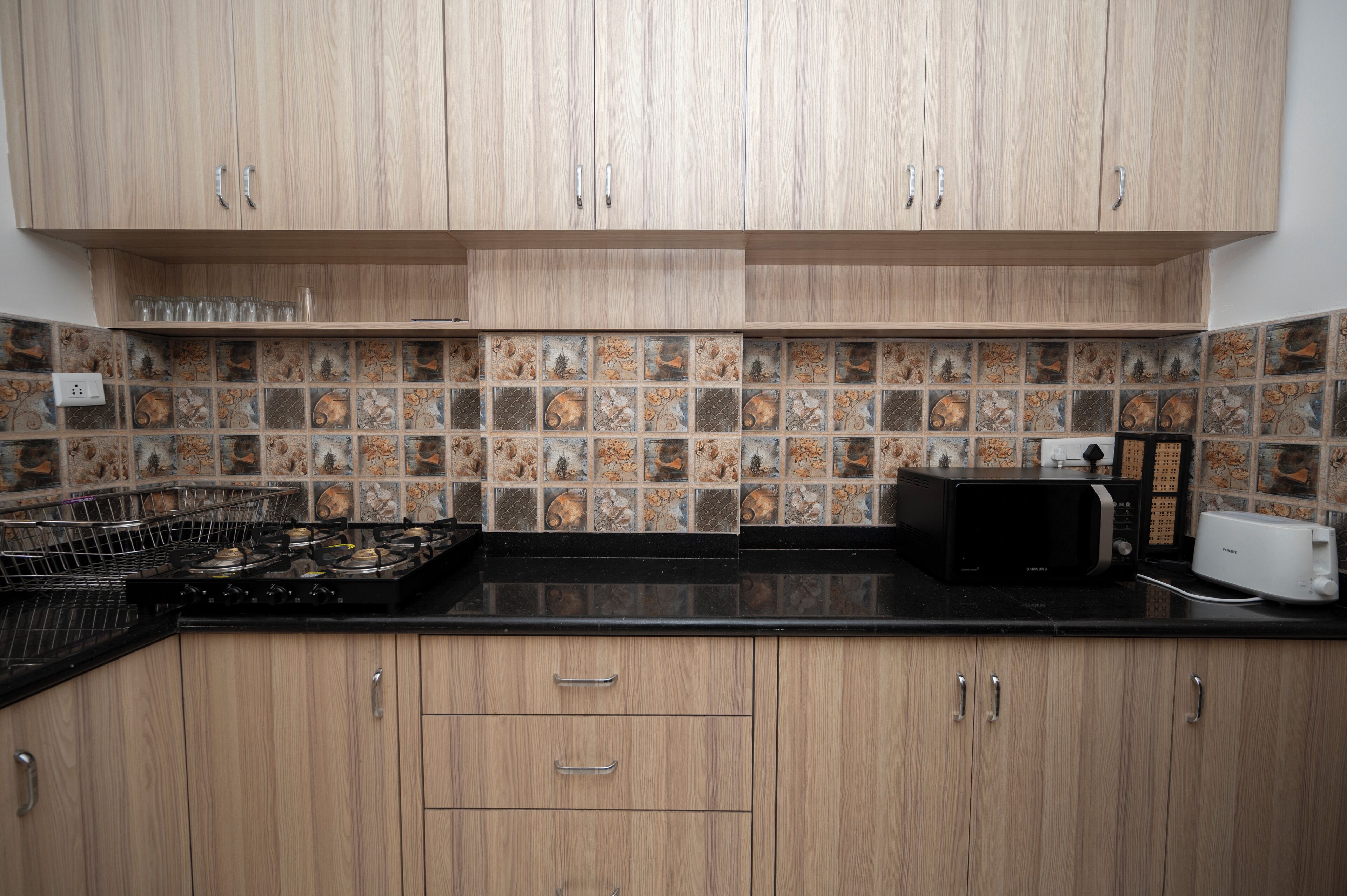 A kitchen with wooden cabinets, a tiled backsplash, a stove, and a microwave.