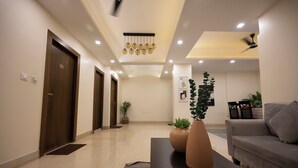 Una hall d'hotel moderna con reception, area salotto e una scala.