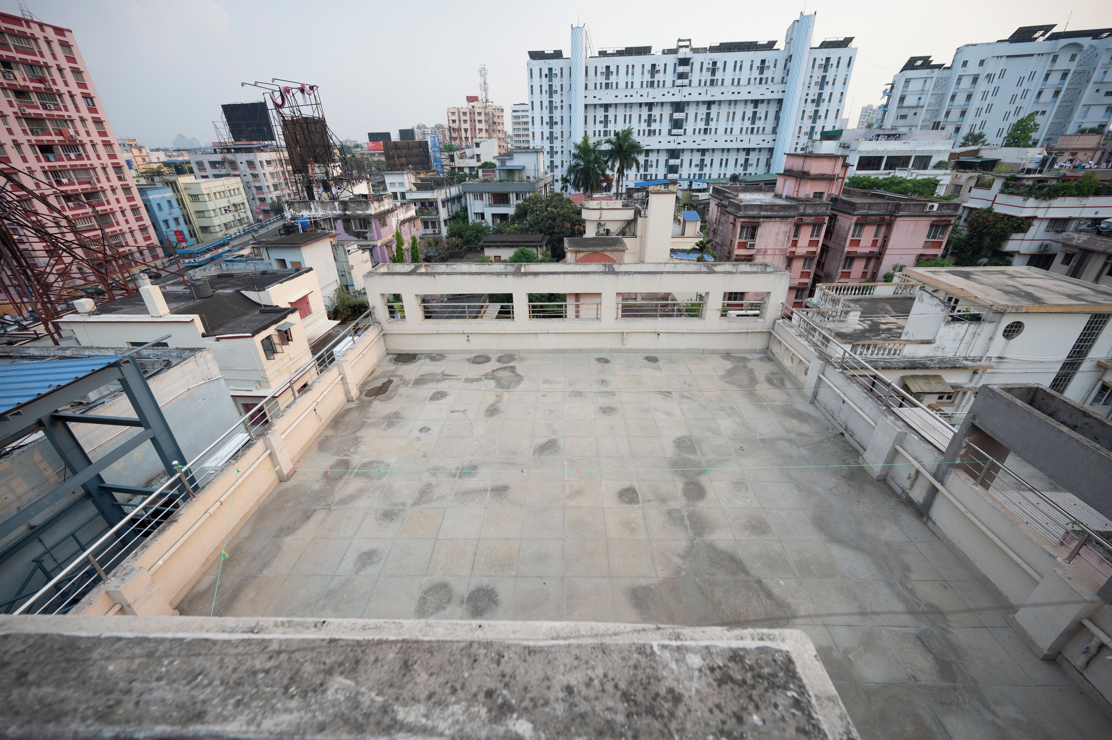 A rooftop terrace with a view of surrounding buildings, including a mix of residential and commercial structures.