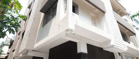 A modern multi-story building with a flat facade, large windows, and a clean, minimalist design.