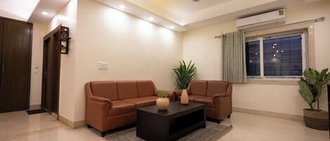 A modern living room with a brown leather sofa, a black coffee table, and a ceiling fan.