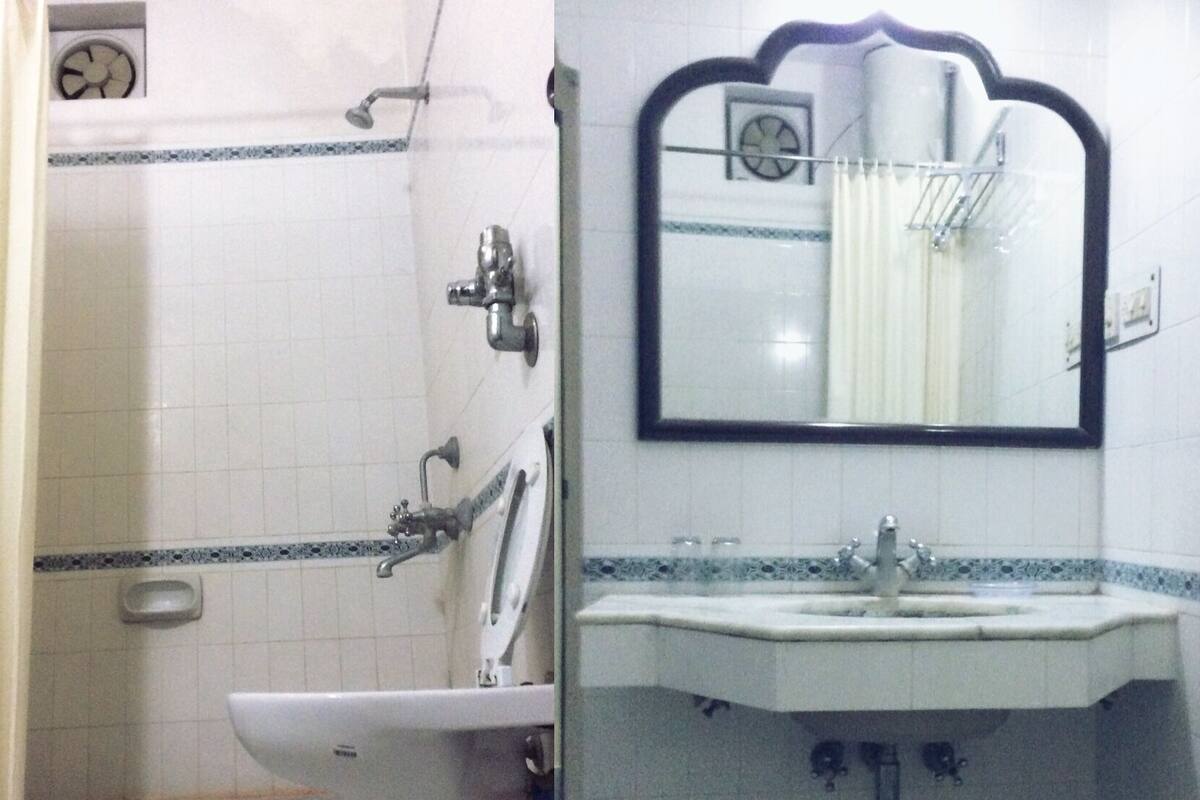A bathroom with a shower, a sink, and a mirror.