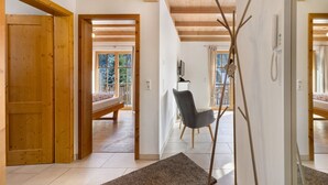 Un interior de madera con una cama, una silla y un televisor.