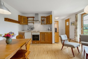 A kitchen with wooden cabinets, a dining table, and chairs.