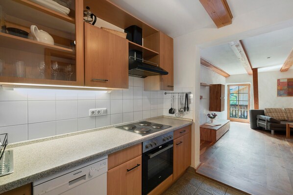 A modern kitchen with wooden cabinets, a Siemens dishwasher, and a black oven.