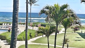 A resort with a pool, palm trees, and ocean views. - Watch Pacific Ocean sunrise from the comfort of your private ocean view lanai! (Lihue)