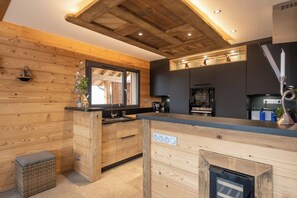 Eine moderne Küche mit Holzvertäfelung, einem eingebauten Ofen und einem Fenster.