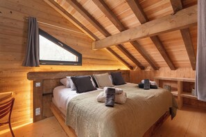 A wooden cabin bedroom with a bed, pillows, a window, and a shelf. - ✨ Chalet L'Anahi ⭐⭐⭐⭐⭐ – 5-Star Luxury Chalet with Panoramic Mountain Views (Gérardmer)