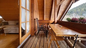 A wooden interior with a dining table, chairs, and a sofa. - Apartment '8 - Flößerstuben' with Mountain View, Shared Terrace and Wi-Fi (Alpirsbach)