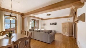 Un comedor con una mesa de madera, sillas y un sofá.