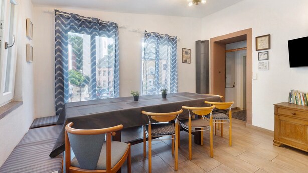 Un espace repas comprenant une table, des chaises et une vue par les fenêtres.