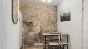 A room with a stone wall, a wooden table, and two benches.