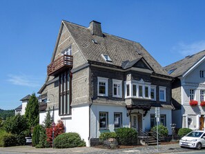 A two-story house with a balcony, a chimney, and a garage. - Apartment 'Sophie Stecker' with Mountain View, Private Terrace and Wi-Fi (Schmallenberg)