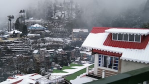A snow-covered village with traditional buildings and a prominent red-roofed structure. - Broadview Homestay  (Darjeeling)
