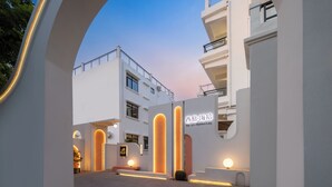 Un bâtiment moderne à la façade blanche, doté de grandes fenêtres et d’une enseigne indiquant qu’il s’agit d’un hôtel.