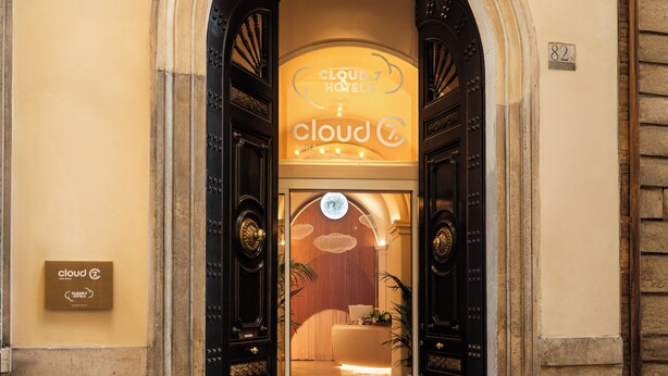 A hotel entrance with a large arched doorway, a sign for 'Cloud Hotel', and a number '82' on the wall. - Cloud 7 Roma Hotel (Rome)