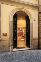 L'ingresso di un hotel con un'ampia porta ad arco, una insegna con la scritta 'Cloud Hotel' e il numero '82' sulla parete.